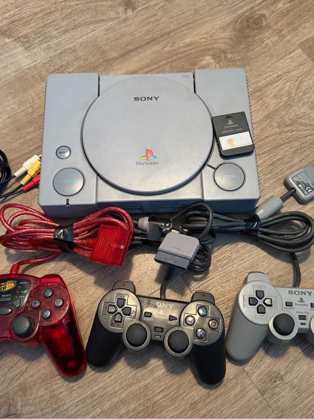 Sony PlayStation Console with Gray, Black & Red Controllers